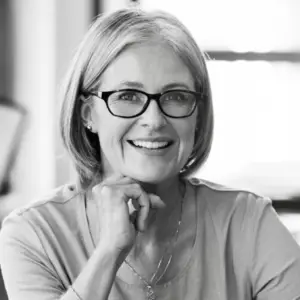 a woman wearing glasses and smiling